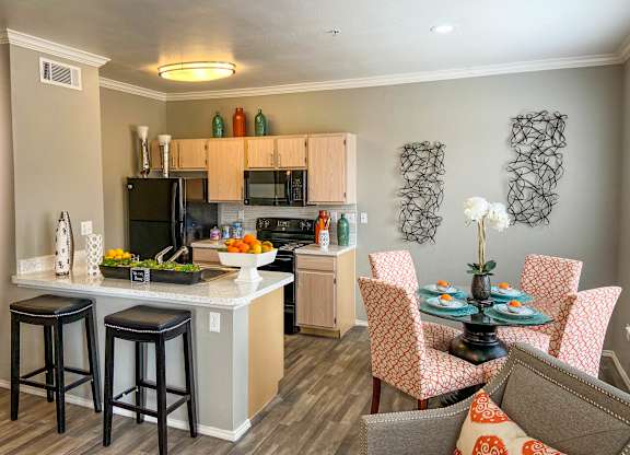 A kitchen with a bar area and a dining table with chairs.