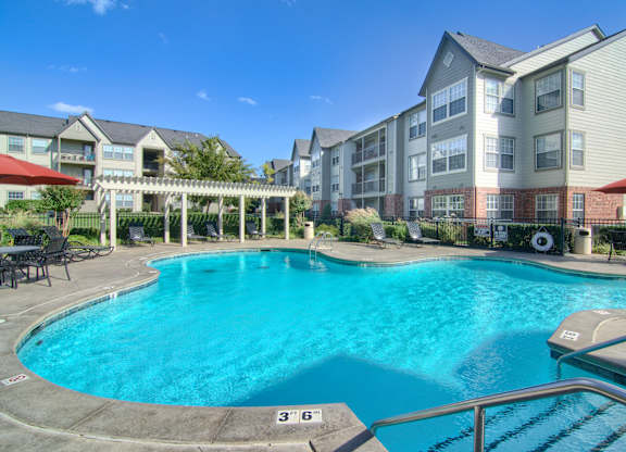 A large swimming pool in front of apartment buildings.