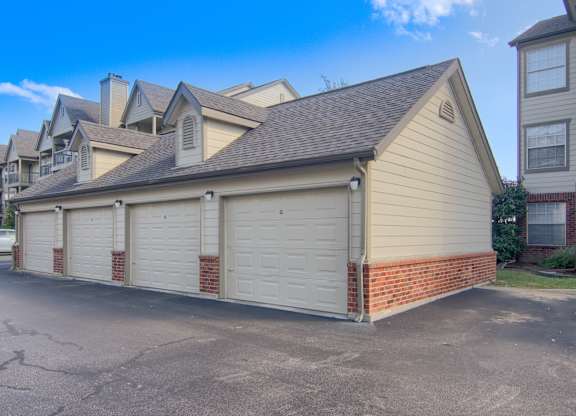 A house with a garage is situated in a driveway.