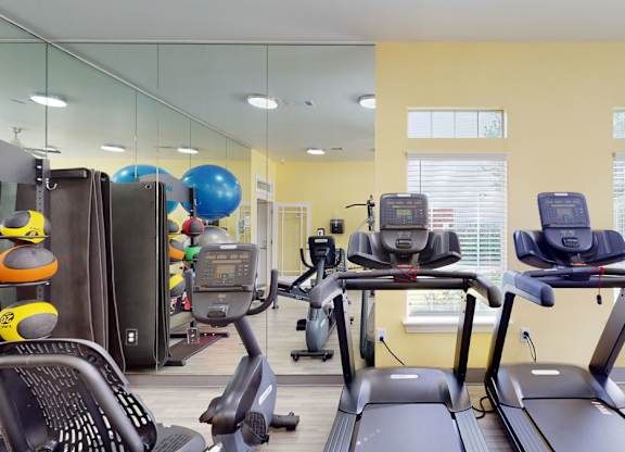 A gym with treadmills, elliptical machines, and other exercise equipment.