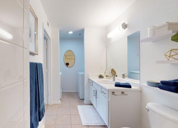 A bathroom with a white tub, sink, and toiletries.