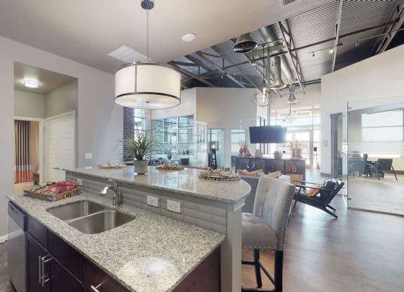 a kitchen with granite countertops and a dining area in the background