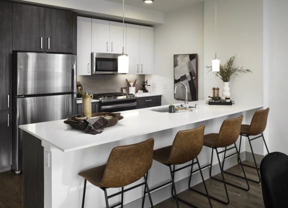 a kitchen with a large island and a stainless steel refrigerator