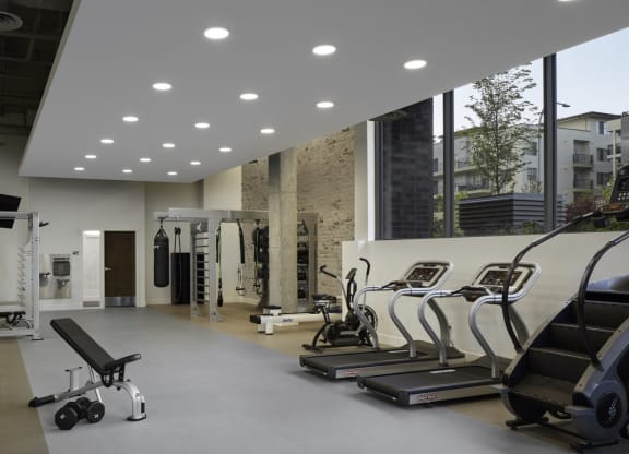 a gym with a lot of exercise equipment and a large window