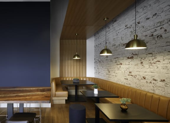 a dining room with tables and chairs and a brick wall