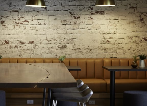a dining room with a table and chairs and a brick wall