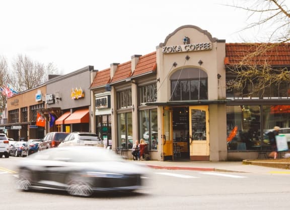 a busy city street with cars and pedestrians and businesses