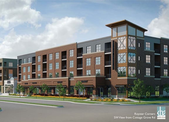 Modern mixed-use building with four stories, brown brick facade, large windows, and retail spaces at the base. Bright, sunny day with a few clouds at Royster Commons Apartments.