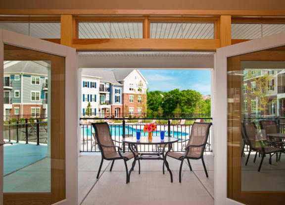 a patio with a table and chairs and a swimming pool