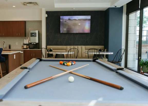 a pool table in a living room with a tv