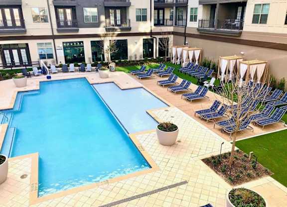 a large swimming pool with lounge chairs around it