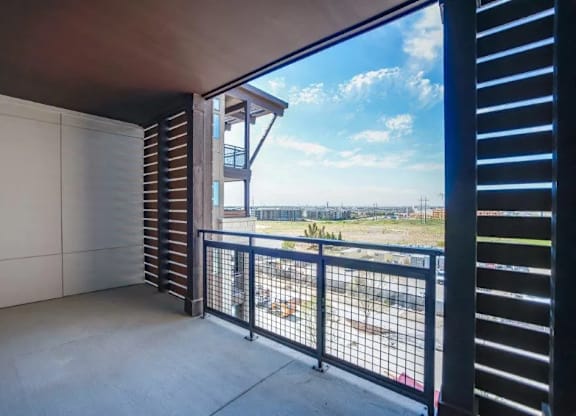 a balcony with a view of a field and a building