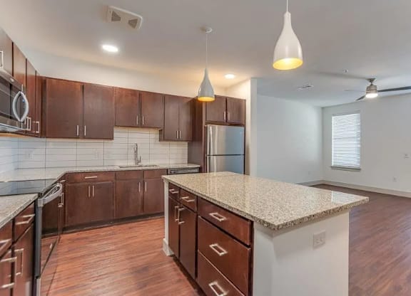 a kitchen with a marble counter top and wooden cabinets