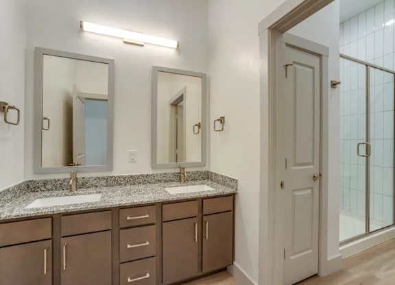 a bathroom with two sinks and two mirrors