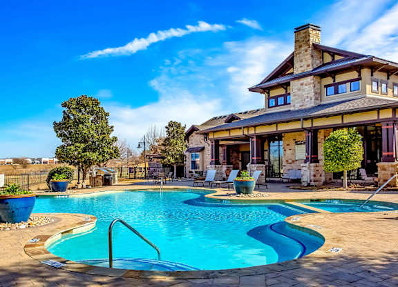 A large house with a pool in front.