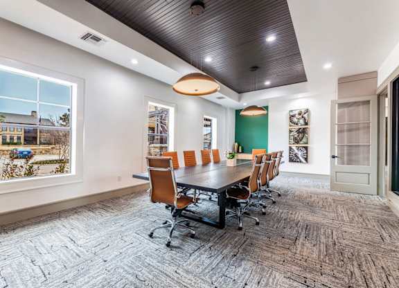 A conference room with a long table and chairs.