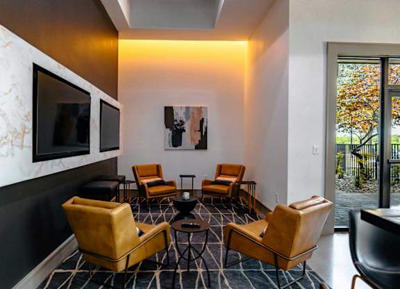 A living room with a television and leather chairs.