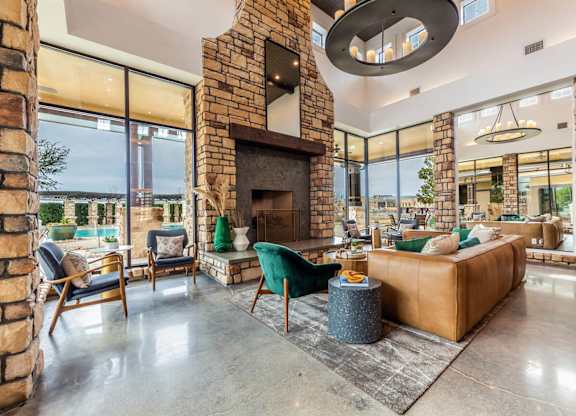 A living room with a stone fireplace and a large window.