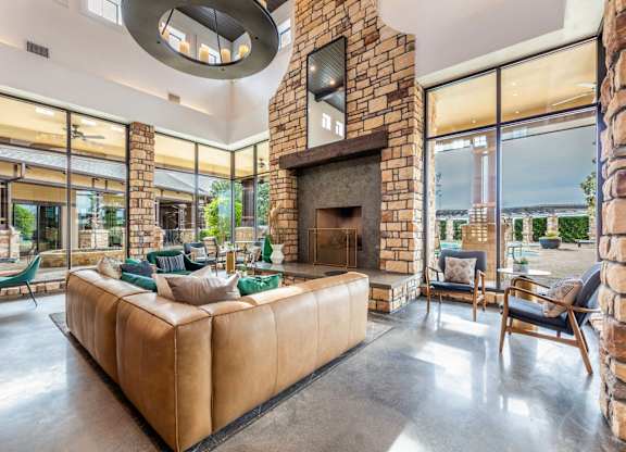 A living room with a stone fireplace and a large couch.