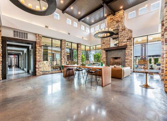 A modern open plan living space with a stone fireplace.
