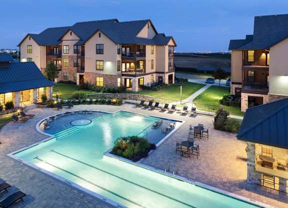 A large building with a pool in front of it.