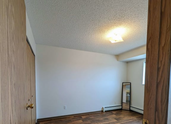 the living room of an empty house with wood flooring