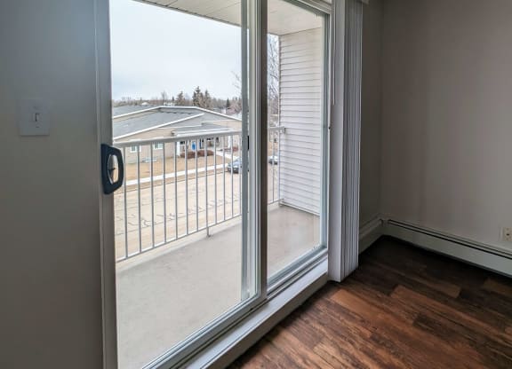 an empty living room with sliding glass doors to a balcony