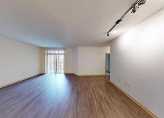 an empty living room with white walls and wood floors