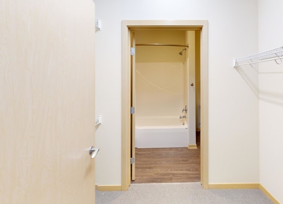 a bedroom with a closet and a door to a bathroom