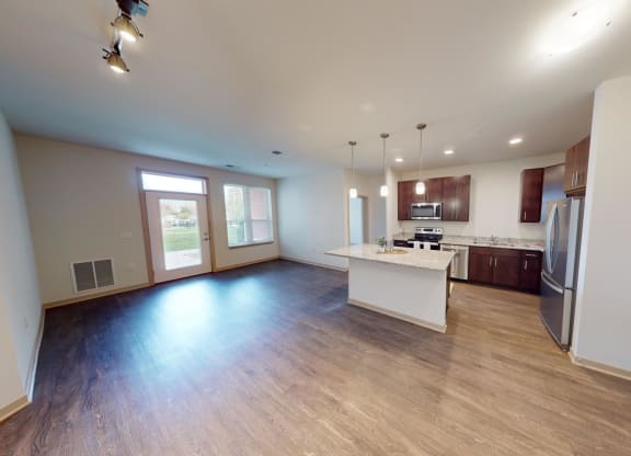 a kitchen and living room with wood floors and white walls