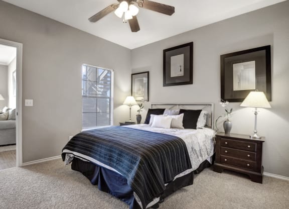 a bedroom with a bed and a ceiling fan