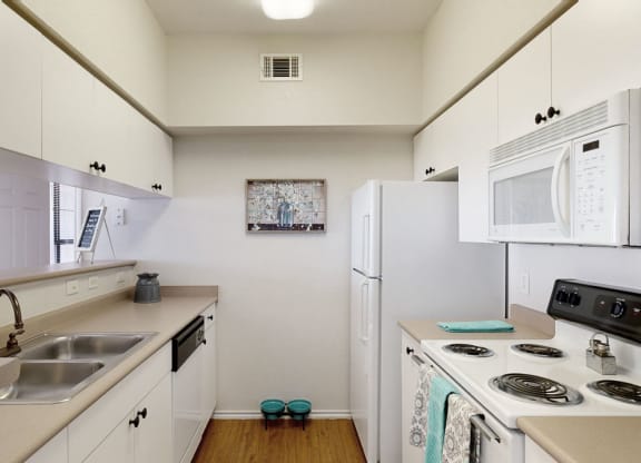 a kitchen with white cabinets and white appliances