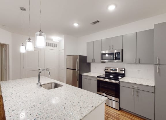 a kitchen with an island and stainless steel appliances