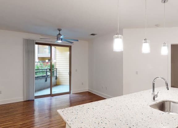 a kitchen with a sink and a ceiling fan