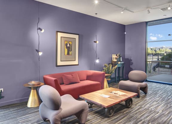 a living room with purple walls and a red couch