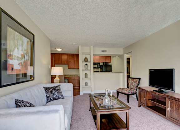 A living room with a white couch and a wooden coffee table.