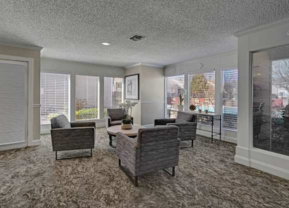 A living room with a grey carpet and furniture.