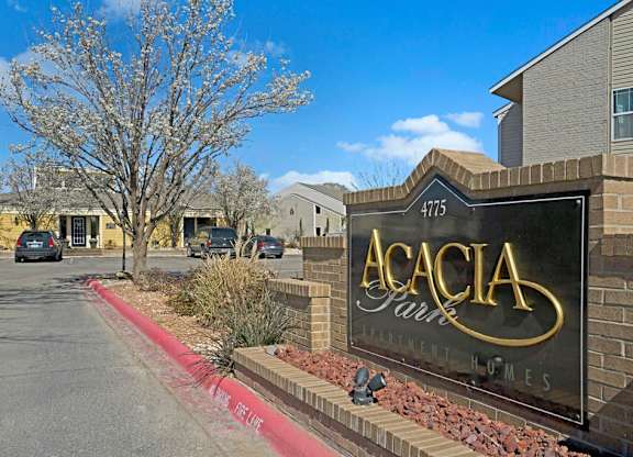 A welcoming community entrance sign at Acacia Park featuring clear signage, landscaped surroundings, mature trees, and a bright, well-kept setting that creates an inviting first impression for residents and guests.