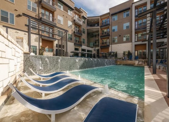 an apartment with a swimming pool in front of an apartment building