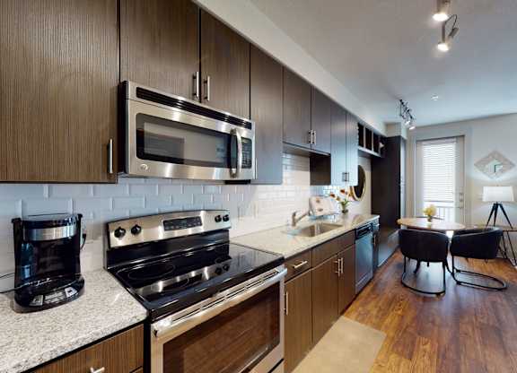 A modern kitchen with dark wood cabinets and stainless steel appliances.