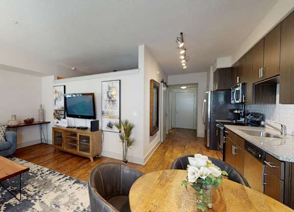 A modern living room with a grey couch, a wooden coffee table, and a flat screen TV.