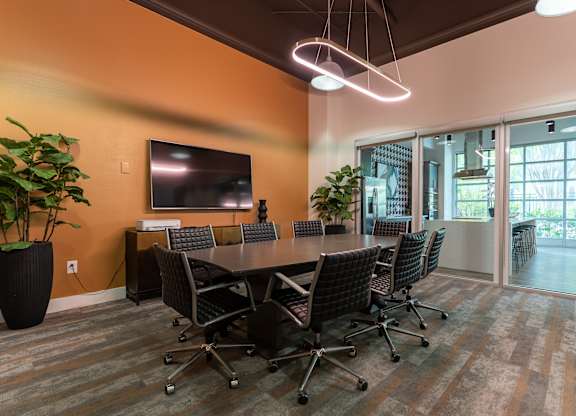 A conference room with a long table and chairs.