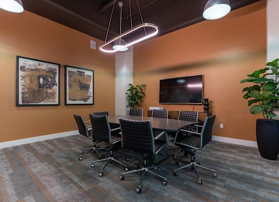 A conference room with a large table and chairs.