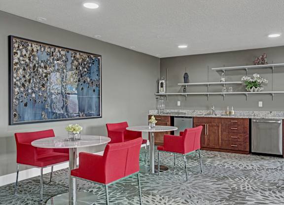 A modern dining room with a large painting on the wall and a patterned carpet.