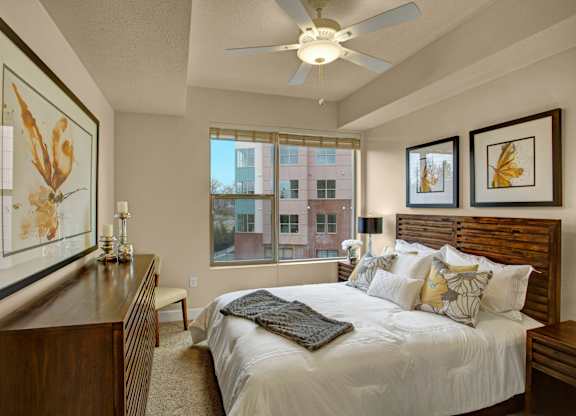 A bedroom with a large bed and a ceiling fan.