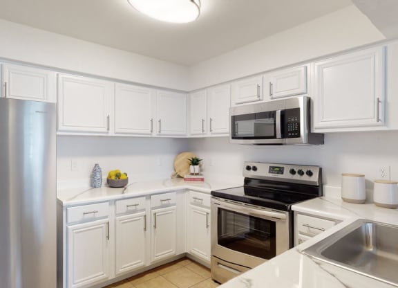 a kitchen with white cabinets and stainless steel appliances
