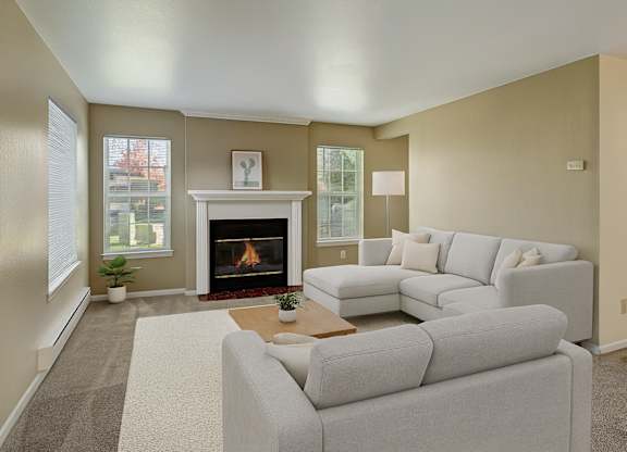 A living room with a fireplace and a grey couch.