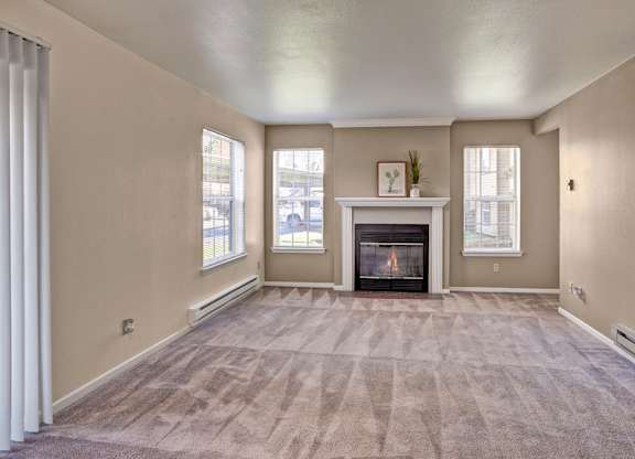 A living room with a fireplace and carpeted floor.