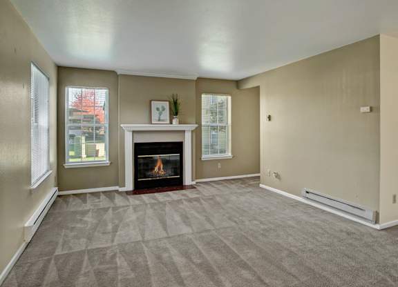 A living room with a fireplace and carpeted floor.