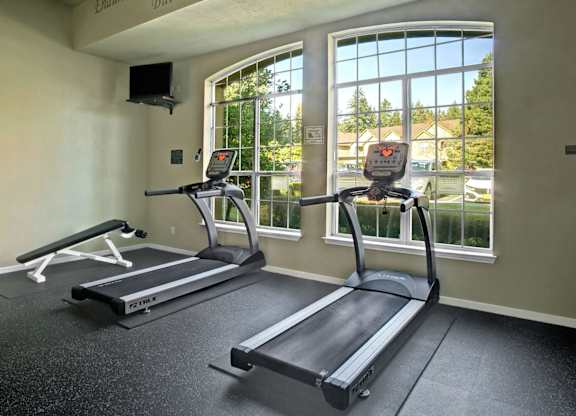 A gym with treadmills and a wall-mounted speaker.